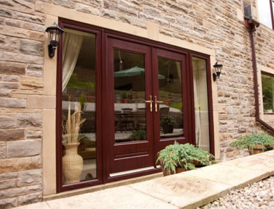 Rosewood French-style glazed pair with side panels in a natural stone wall